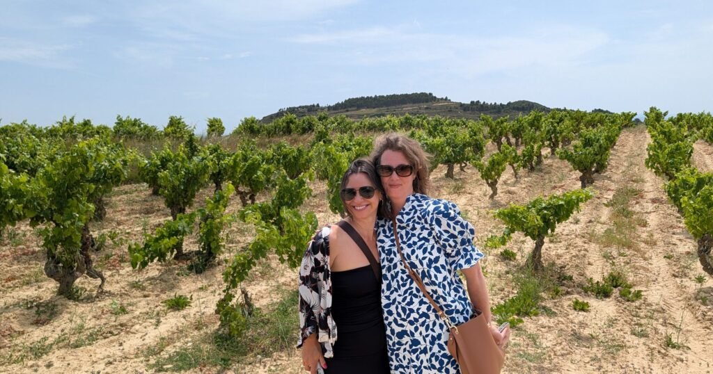 Two people standing amongst their own vines and vineyard in La Rioja